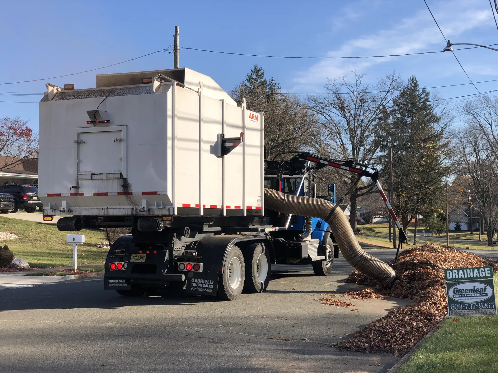 A leaf vacuum truck clears a curbside pile of leaves in Ewing Township, New Jersey. The picture does not show Cary's crews.