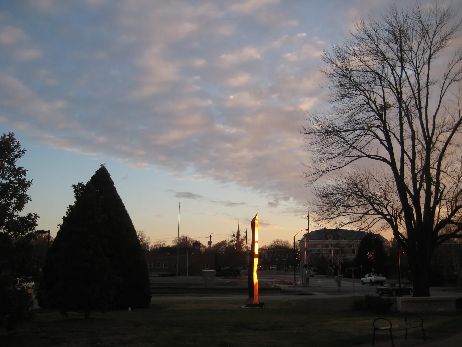 A sculpture on the lawn of the Cary Town Hall campus at dusk.