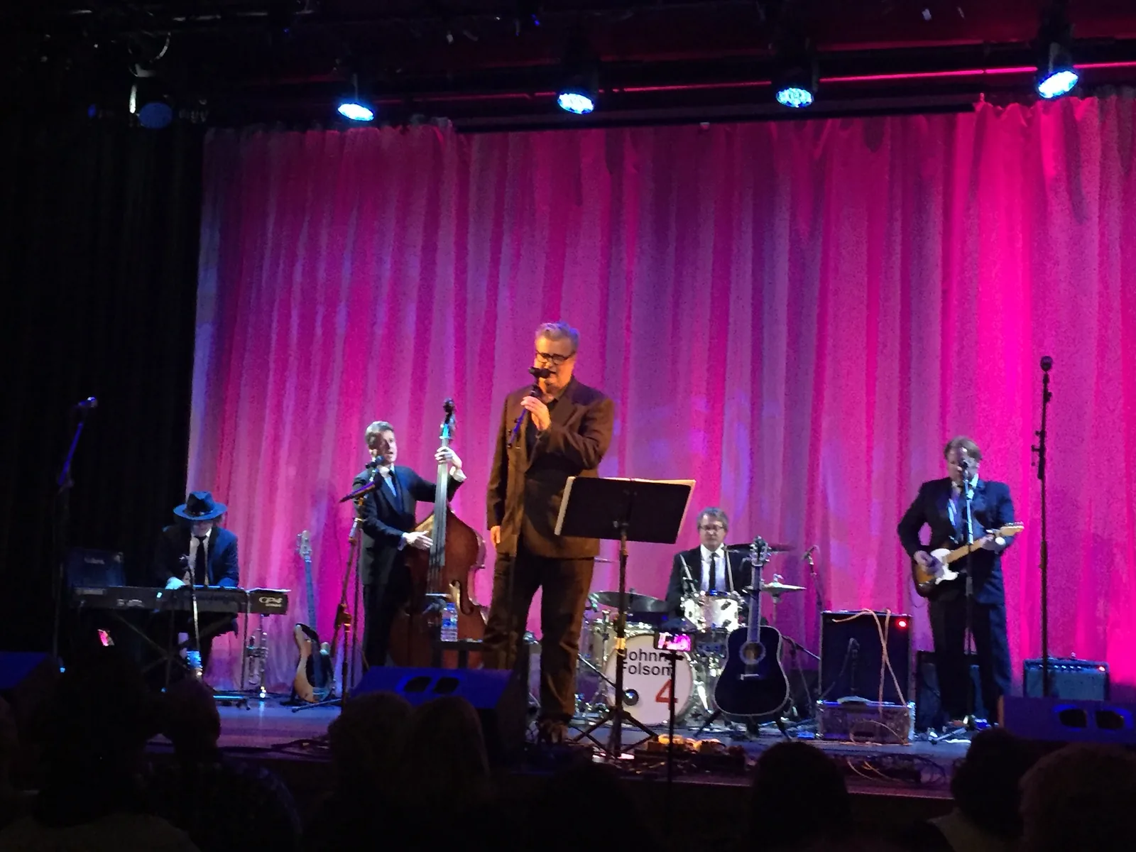 A band on stage under pink lights at The Cary Theater on East Chatham Street.