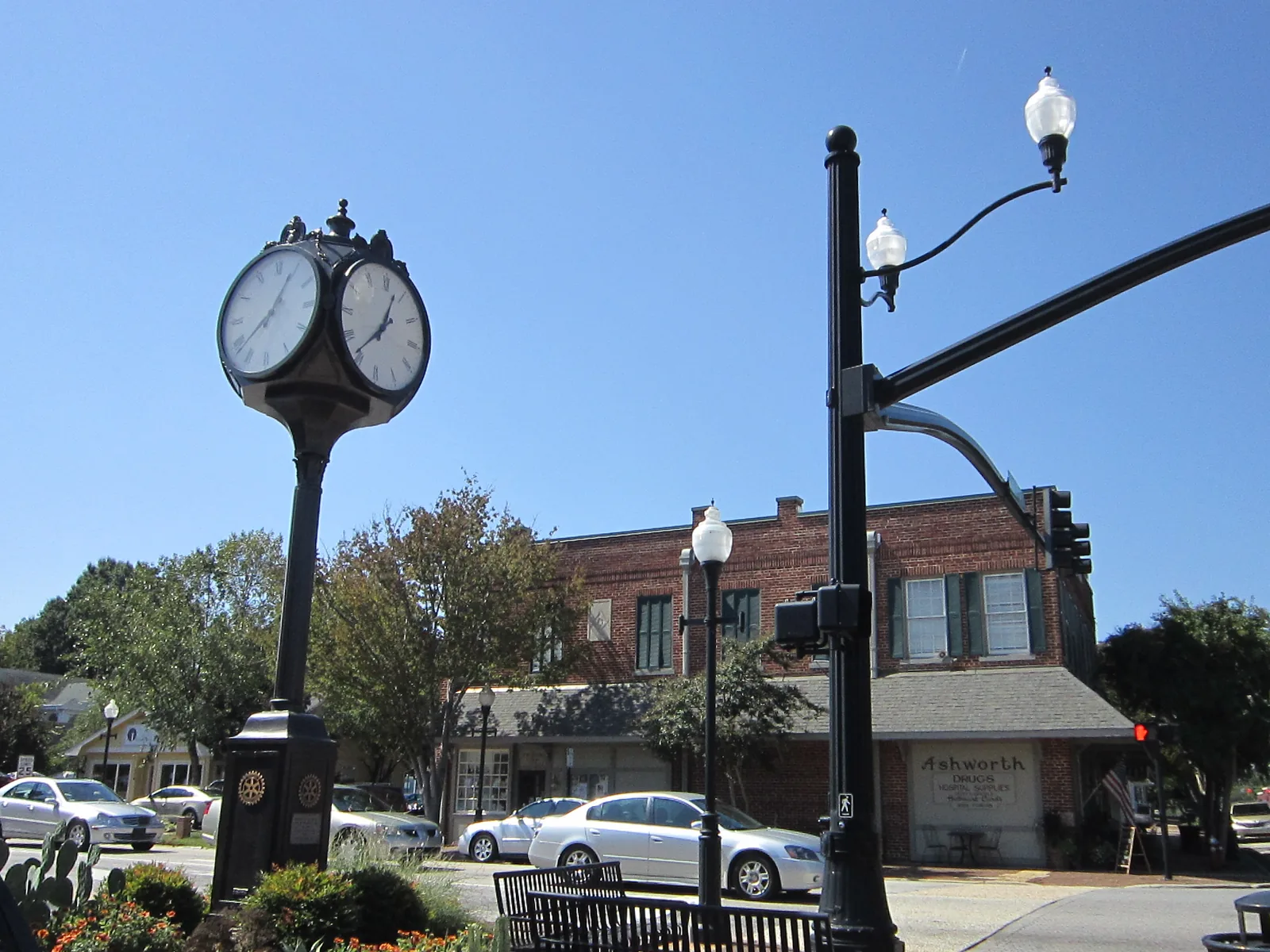 The four-faced clock at the corner of Academy and Chatham streets in downtown Cary, with Ashworth Drugs behind it.