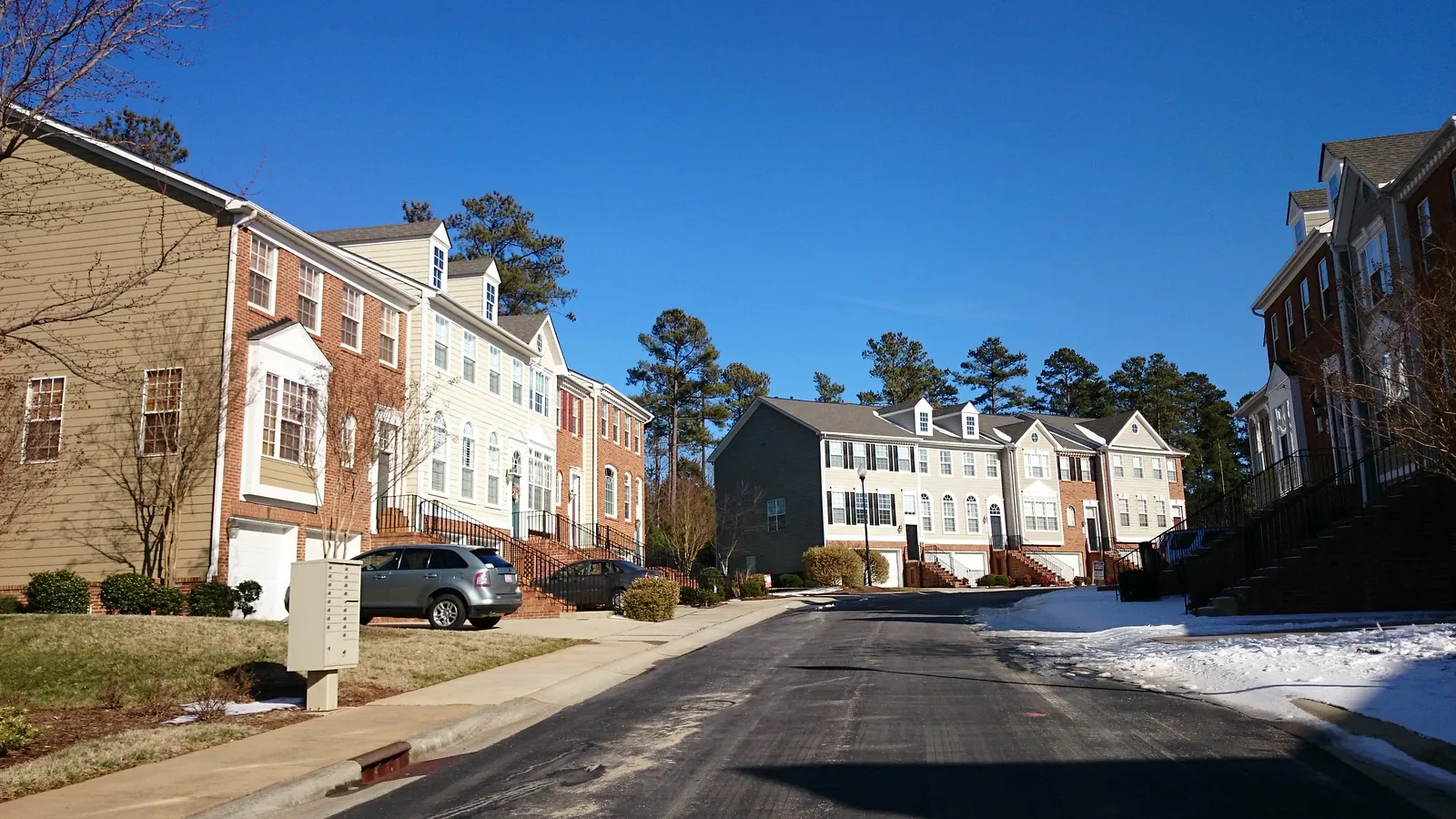 Brick and sided townhomes line a residential street in Cary.