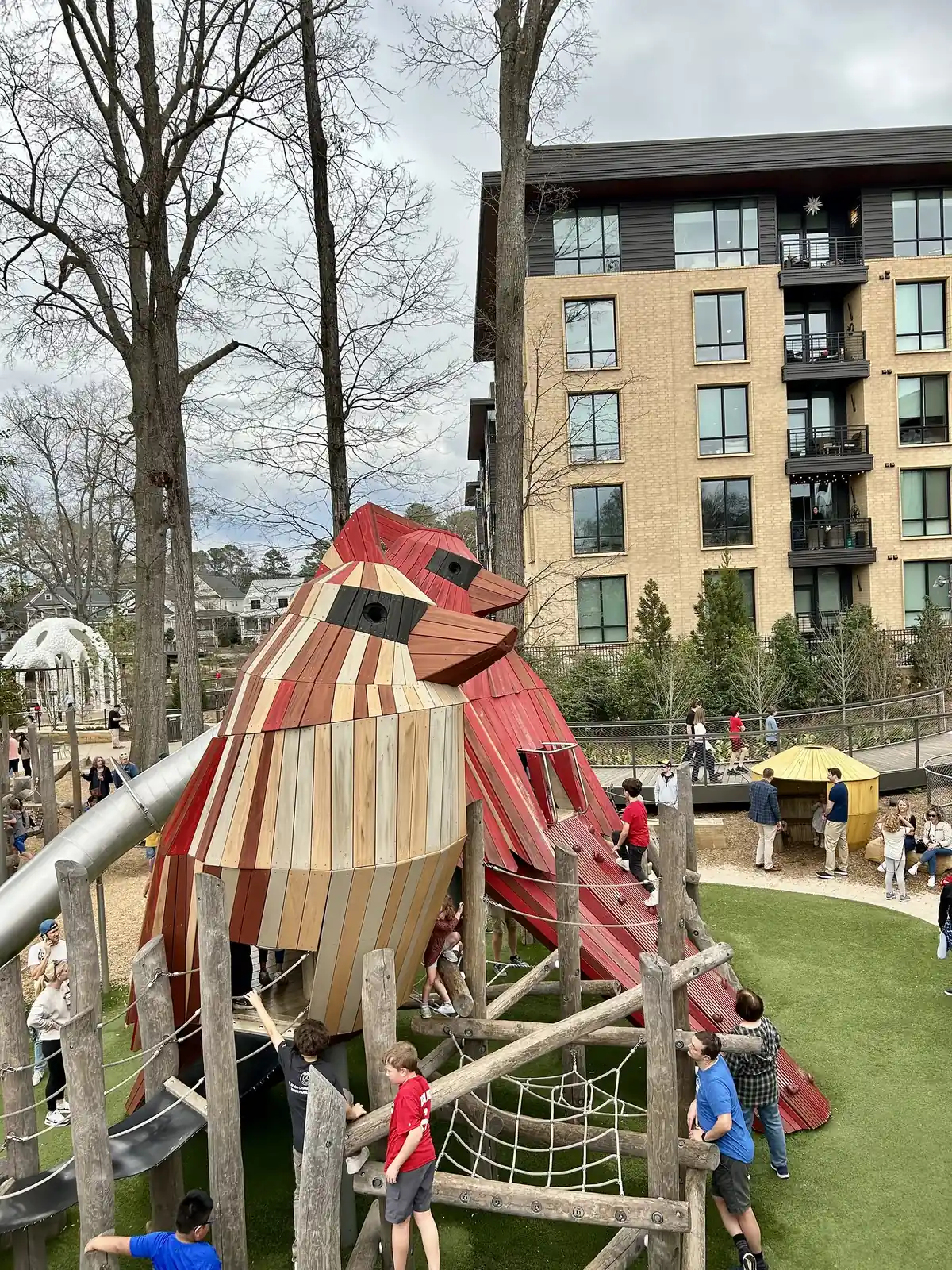 Children climbing the giant wooden cardinals at The Nest playground in Downtown Cary Park.