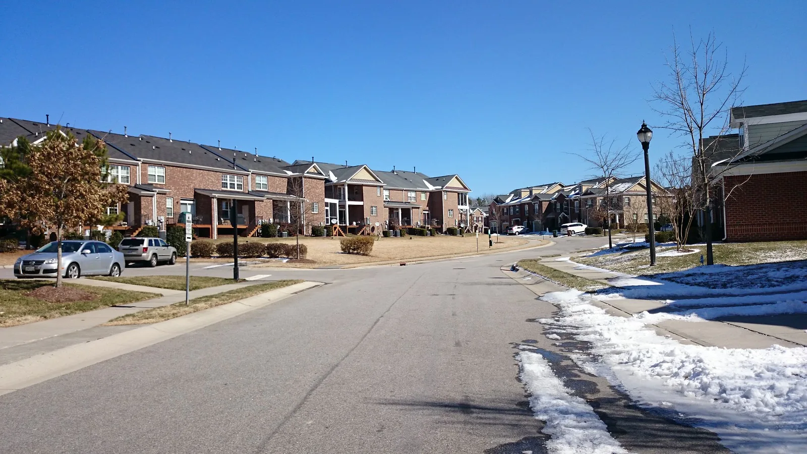 Brick townhomes along a curving residential street in Cary.