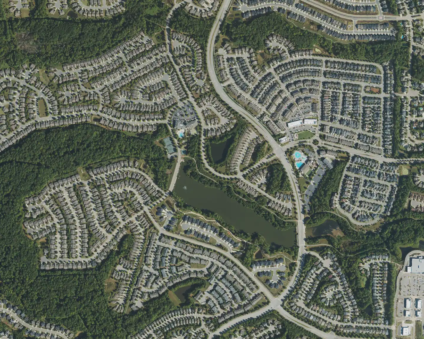 Aerial view of homes, a lake and community pools in the Amberly area of west Cary