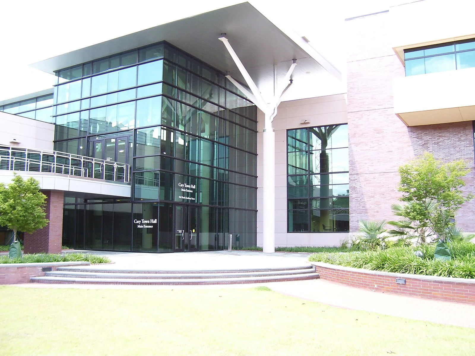 The glass main entrance of Cary Town Hall on North Academy Street, home of the Council Chambers where the Town Council holds its public hearings.