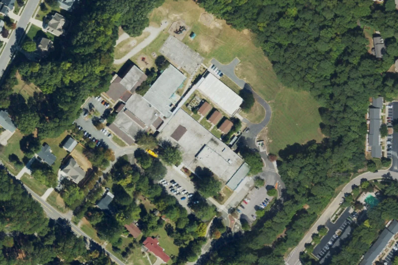 Northwoods Elementary School's buildings among the trees off Chapel Hill Road, seen from the air