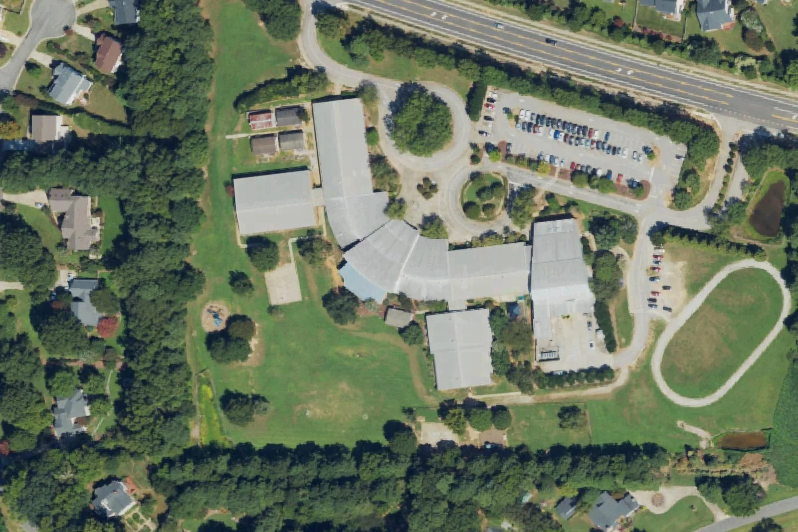 Oak Grove Elementary School's curved building, field and track on Penny Road, seen from the air