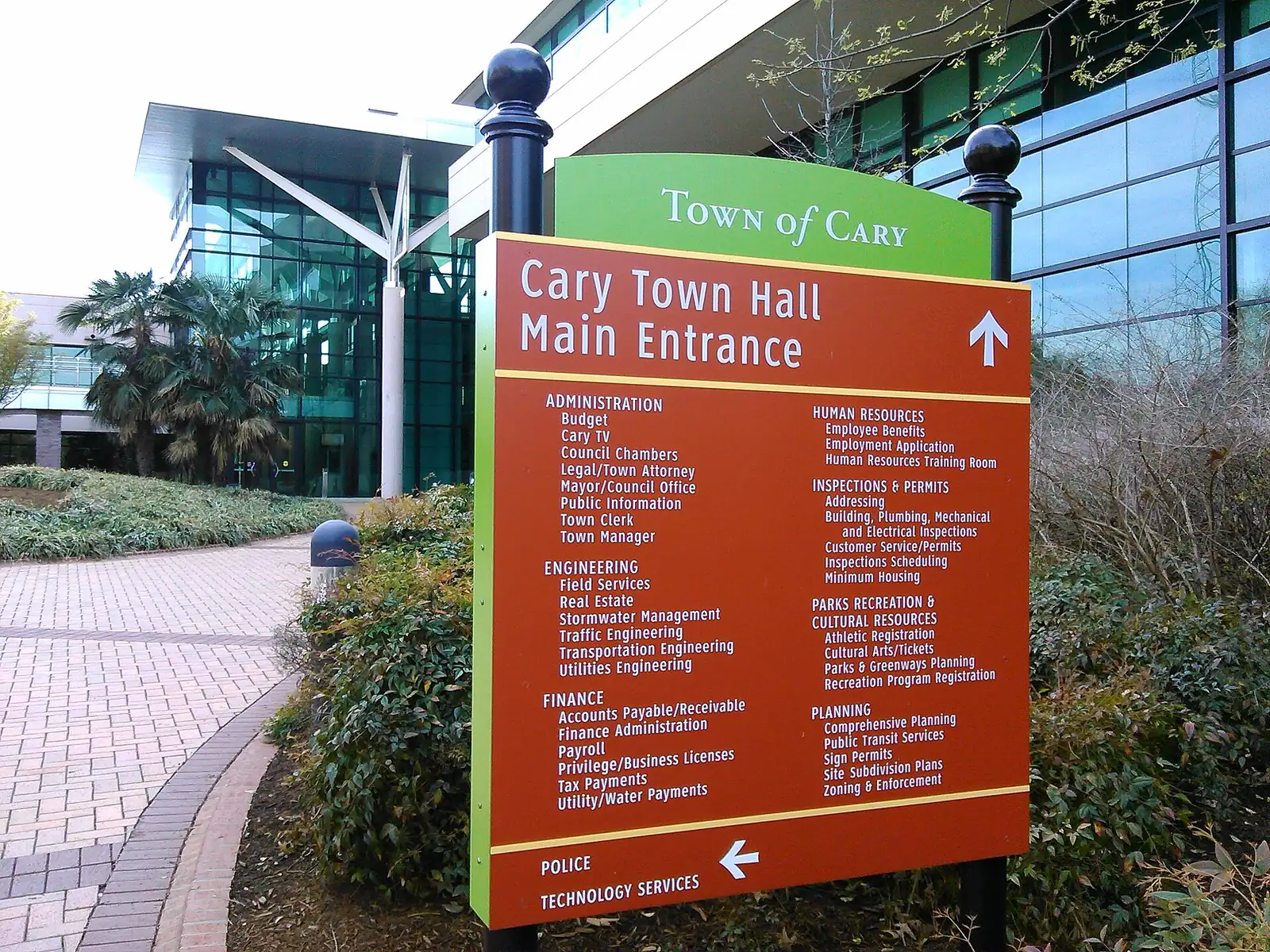 The directory sign at the main entrance of Cary Town Hall on North Academy Street lists the departments inside, from the Town Clerk to Inspections and Permits.